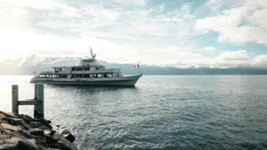 Bateau de passagers naviguant sur le lac Léman avec les Alpes en arrière-plan.