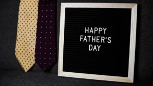 Message Happy Father's Day sur une ardoise avec deux cravates en arrière-plan.
