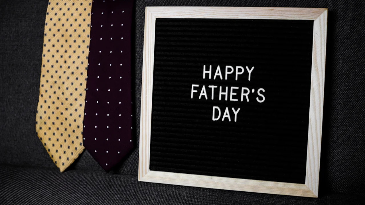 Message Happy Father's Day sur une ardoise avec deux cravates en arrière-plan.