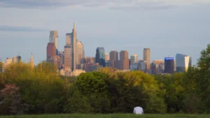 Vue panoramique de la ligne d'horizon de Philadelphie surplombant un espace vert arboré.