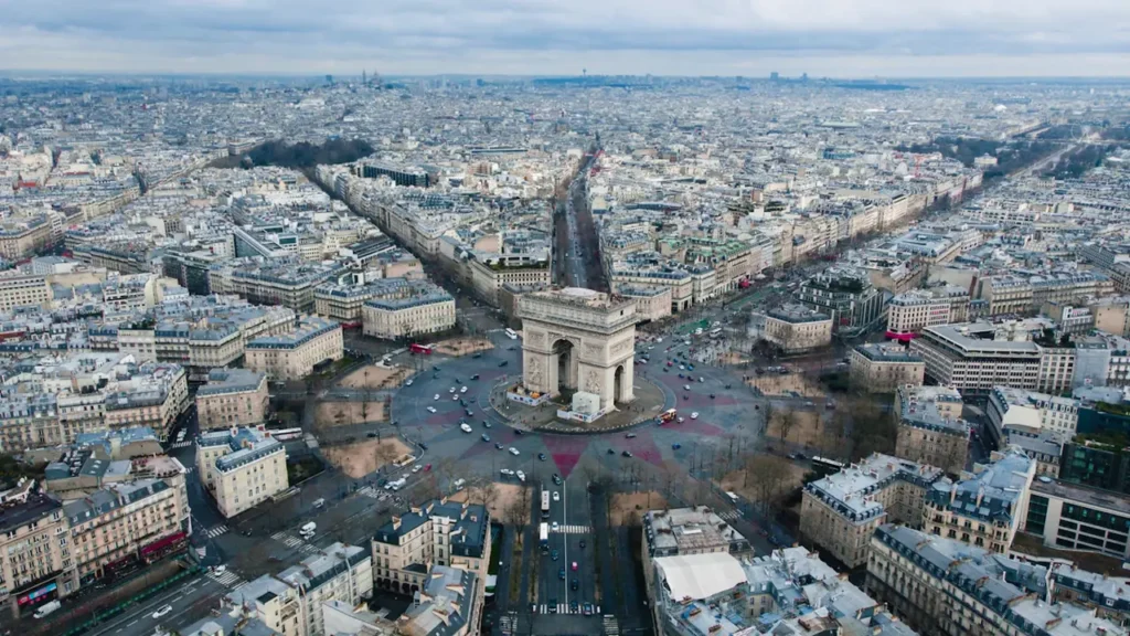 Vue aérienne panoramique de Paris avec la tour Eiffel sous un ciel bleu dégagé.
