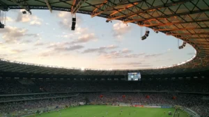 Vue panoramique d'un grand stade de football sous un ciel crépusculaire.