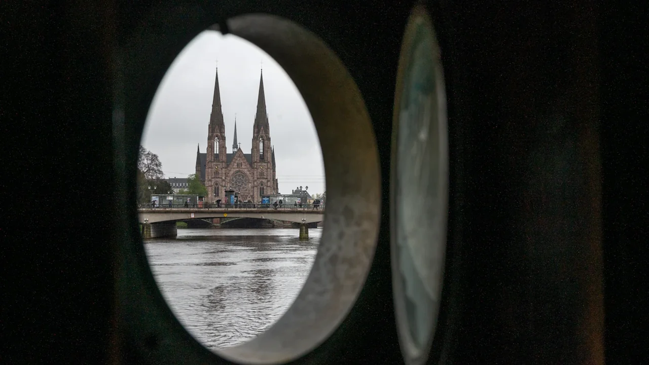 Vue encadrée d'une cathédrale au bord de l'eau, symbolisant la perspective et l'analyse financière.