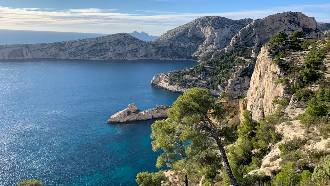 Vue aérienne des calanques de Marseille avec rochers escarpés et mer Méditerranée bleue.