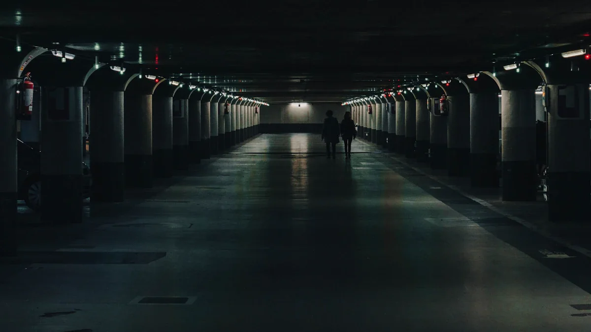 Deux personnes marchent dans un parking souterrain sombre et désert à Metz.