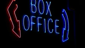 Enseigne néon lumineuse indiquant 'Box Office' dans une obscurité totale.