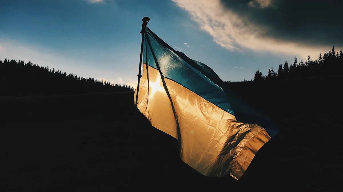 Le drapeau ukrainien flotte fièrement sous un ciel dramatique au-dessus d'un paysage montagneux.