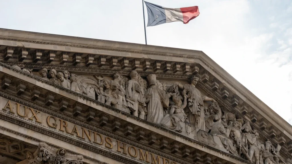 Le drapeau français flotte fièrement au sommet d'un bâtiment historique à Paris.