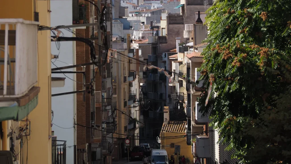 Une rue étroite entourée de bâtiments anciens et d'arbres à Saint-Étienne.