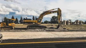 Engins de chantier jaunes effectuant des travaux de terrassement sur un site routier.