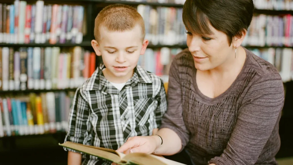Une mère et son fils lisant ensemble dans une bibliothèque municipale fraîche et calme.
