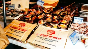 Plateaux de coquilles Saint-Jacques fraîches sur l'étal d'un marché brestois.