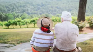 Couple âgé assis paisiblement profitant d'une vue dégagée en extérieur.