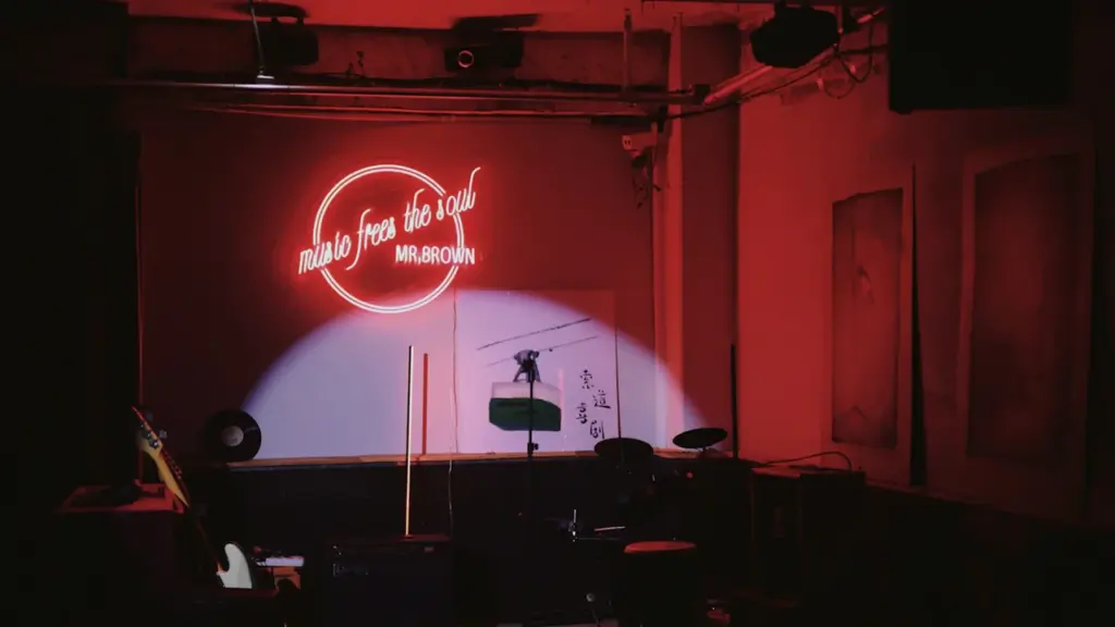 Une scène de spectacle vide éclairée par un projecteur dans une salle sombre.