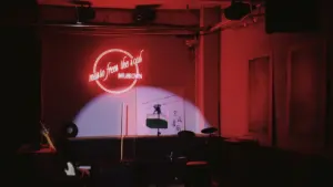 Une scène de spectacle vide éclairée par un projecteur dans une salle sombre.