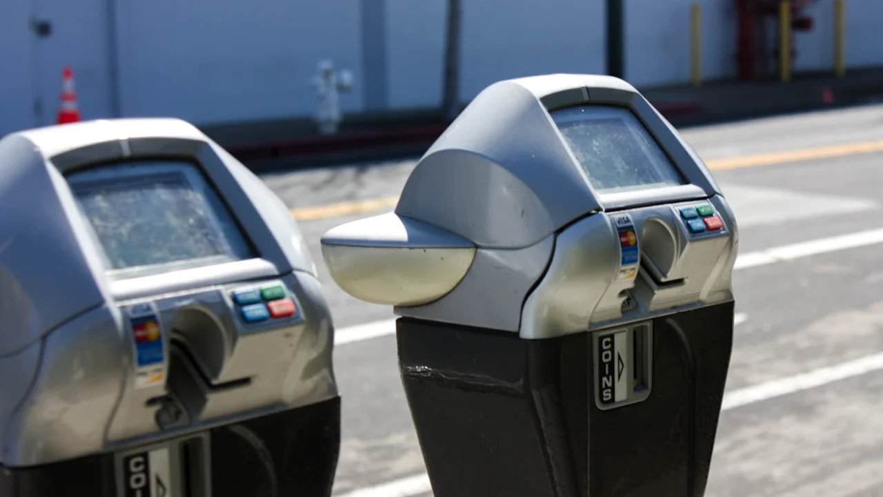 Deux horodateurs modernes installés sur un trottoir en milieu urbain.