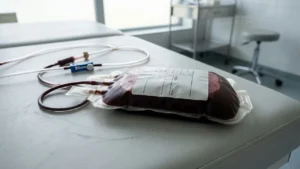 Poche de sang rouge sur une table d'examen médicale avec des tubes en plastique.