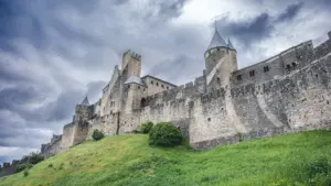 Les fortifications historiques et imposantes de la cité médiévale de Carcassonne sous un ciel nuageux.