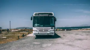 Un bus de tourisme blanc stationné sur une route dégagée lors d'une journée ensoleillée.