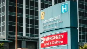 Panneau extérieur du centre hospitalier indiquant les services d'urgence pour adultes et enfants.