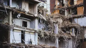 Façade d'un immeuble en démolition révélant des espaces de vie intérieurs détruits.