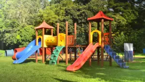 Aire de jeux colorée dans un parc verdoyant pour les activités des enfants.