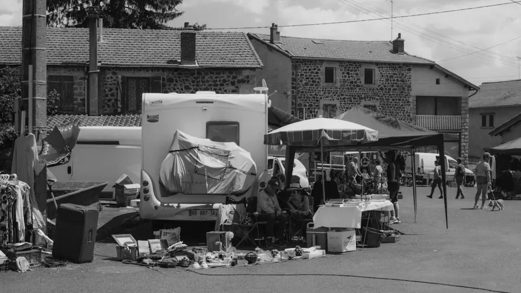 Étalage de brocante en plein air avec des parasols et divers objets anciens.
