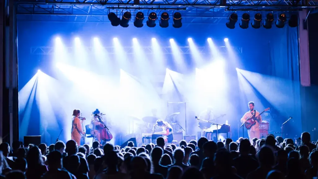 Un groupe de musique se produit sur scène devant une foule lors d'un festival.