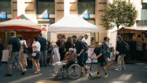 Des personnes de tous âges flânent au marché en plein air dans une ville française.
