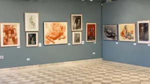 Galerie d'art contemporain exposant une sélection de dessins encadrés sur des murs gris.