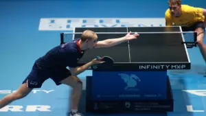 Un joueur de tennis de table effectue un service devant un adversaire attentif en tournoi.