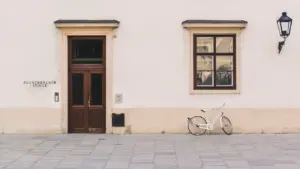 Un vélo blanc garé contre un bâtiment historique près d'une fenêtre et porte