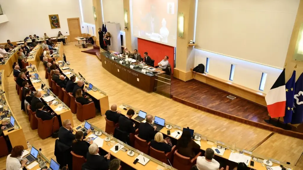 Une salle de conseil métropolitain avec des élus travaillant sur des ordinateurs portables.